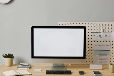 Front view computer with blank white screen on desk in minimal home office setup Foto stock