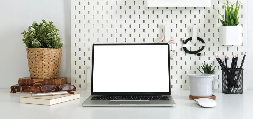 Front view computer laptop with blank screen, book, coffee cup and houseplant Stock Photos