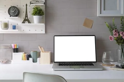Front view computer laptop with empty display, books and potted plant on wh.. Stock Photos