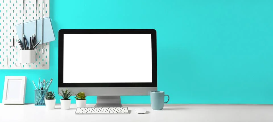 Front view computer pc and office supplies on white table with light blue wall Stock Photos