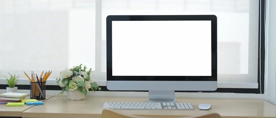 Front view computer pc with blank screen, flower pot and supplies on wooden Foto stock