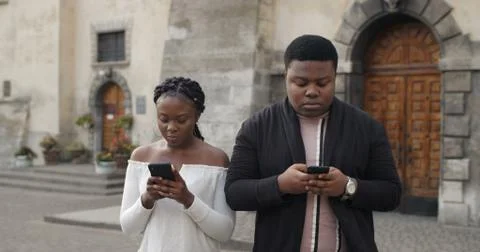 Front view of couple ignoring each other and using their mobilephones while Stock Photos