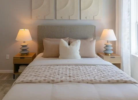 Front view of cozy double bed with stacked pillows Stock Photos