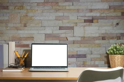 Front view of cozy working space with laptop computer, books, pencil holder.. Foto stock