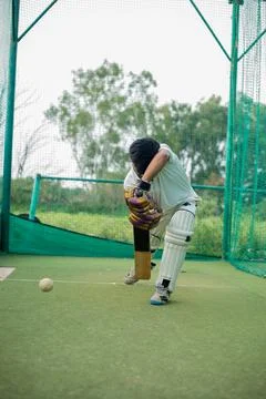 Front view of Cricket player strikes ball during net practice. Stock Photos