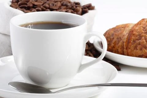 Front view of a cup of hot coffee with croissants and beans Stock Photos