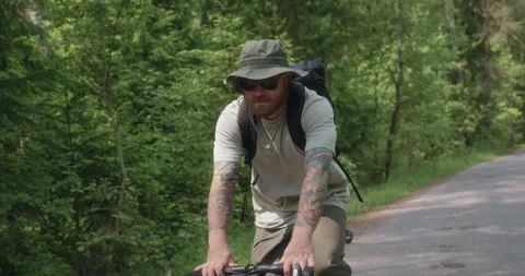 Front view of cyclist riding through green forest Stock Footage 311934680