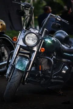 Front view of dark green touring motorcycle with high handlebars parked out.. Fotos Stock