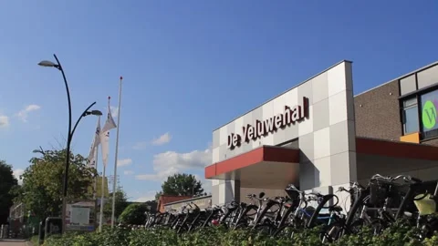 Front view of de veluwehal barneveld building in blue sky and lots of bikes Stock Footage 213916590