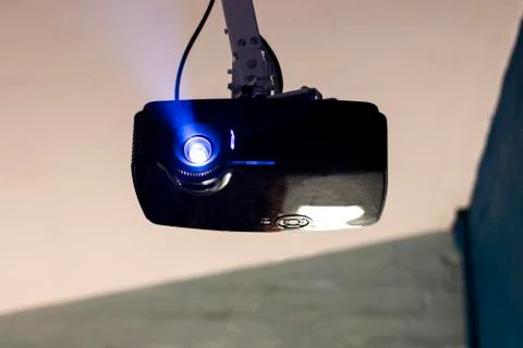 Front view of a digital projector shinning blue light from lens Stock Photos