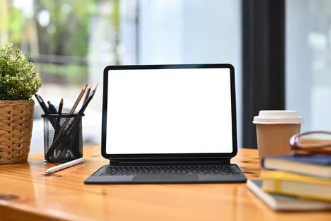 Front view digital tablet, pencil holder, coffee cup and book on wooden table Stock Photos