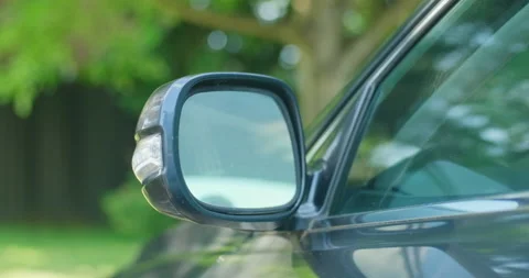 Front view of driver's side rear view mirror of a parked luxury car closing Stock Footage 199653688