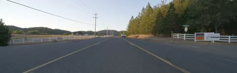 Front view of a Driving Plate: Car travels at dusk through an affluent rural Stock Footage 59329539