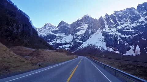Front view of driving road in Norway passing heavy mountains with snow on top 動画素材 90482674