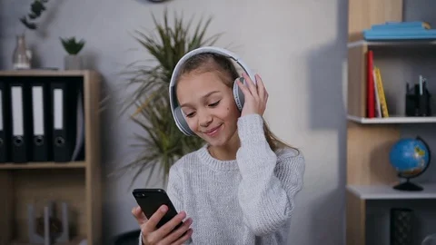 Front view of elated good-looking smiling 15-aged girl which listening Stock Footage 124544349