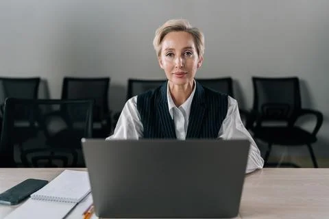 Front view of elegance middle-aged businesswoman executive top manager sitting Stock Photos