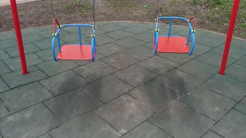 Front view on empty swings on child playground 動画素材 153631008