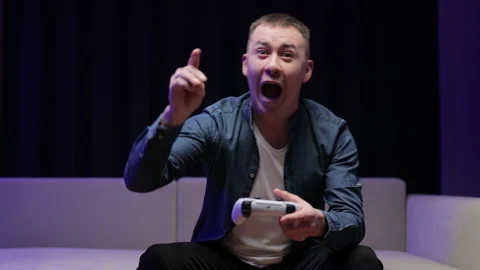 Front view of excited guy playing video game and using joystick . Handsome man Stock Footage 194551065