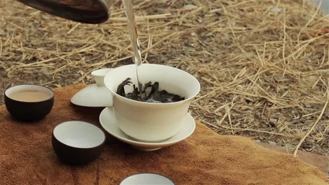 Front view faceless person pouring water into tea bowl cup  動画素材 119959710