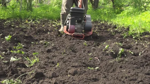 Front view, farmer plowing the land with manual motor plow, throwing soil. Stock Footage 133005259