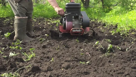 Front view,  farmer in a suburban area plowing the land. Video stock 133005682