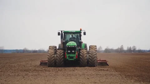 Front view of a farmer on a tractor plowing field, cultivating fertile soil. A Stock-Footage 261933563