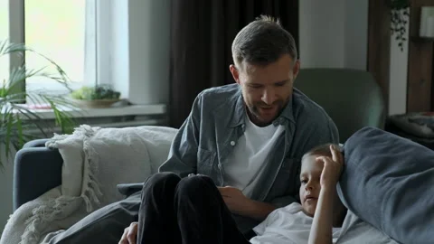 Front view of father and son using smartphone in a comfortable home Stock Footage 156899287