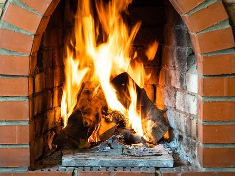 Front view of fire in brick fireplace in house Stock Photos