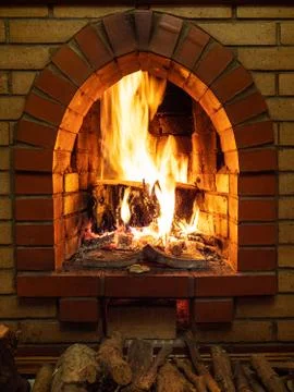 Front view of fireplace with fire and firewood Stock Photos