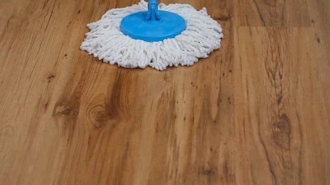 Front view of a flat wet mop wiping slowly back and forth the parquet in the Stock Footage 122378895