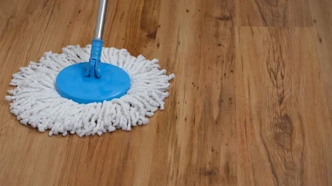 Front view of a flat wet mop wiping slowly left and right the parquet in the Stock Footage 122379666