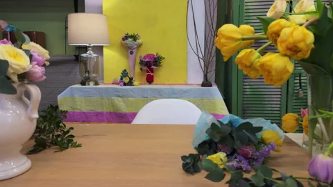 Front view of the florist's workplace, table with different flowers in vases Video stock 307088912