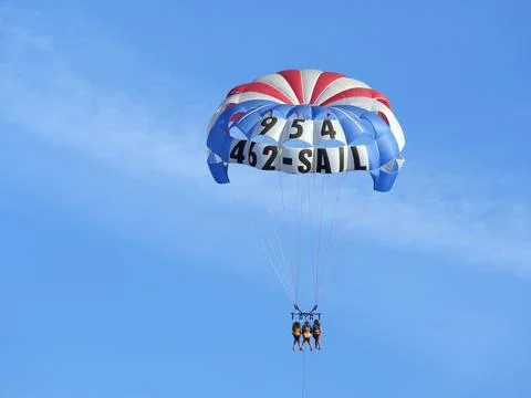Front view of a flying parasail with three people in it. Foto stock
