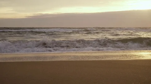 Front view of a foam wave falling on the sand beach Stock Footage 82971344