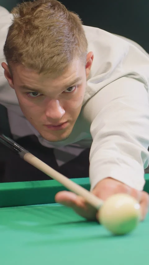 Front view of focused billiard player gripping cue stick over green pool table Stock Footage 319798734