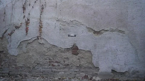 Front view of foldable drone hovering in front of the old wall Stock Footage 98378732