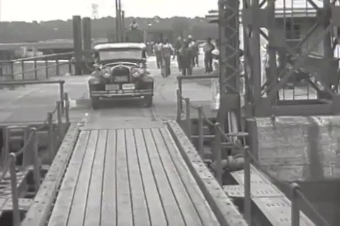 Front view of a Ford car as it drives and several cars drive in line - 1931 Vidéo 96305521