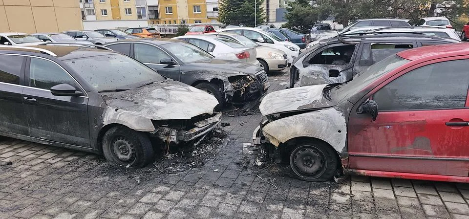Front view of four fire-damaged cars with melted hoods and shattered windows Foto stock