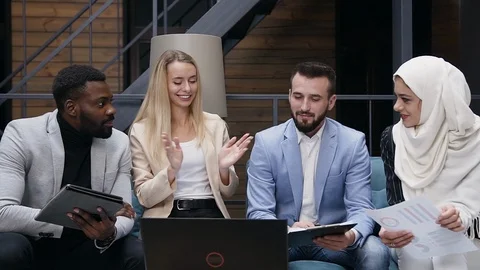 Front view of four young international business partners having meeting and Stock Footage 121518613