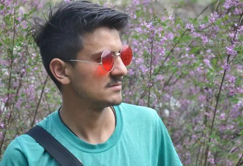 Front view of a good looking Indian guy wearing sunglass while standing outdoor  Stock Photos