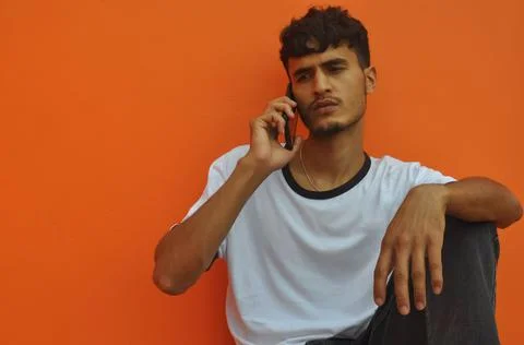 Front view of a good looking Indian guy making phone call with looking sideways Stock Photos