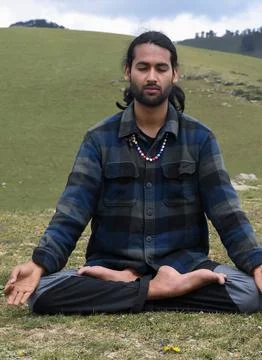 Front view of a good looking Indian young man practicing Yoga in Lotus Pose Stock Photos