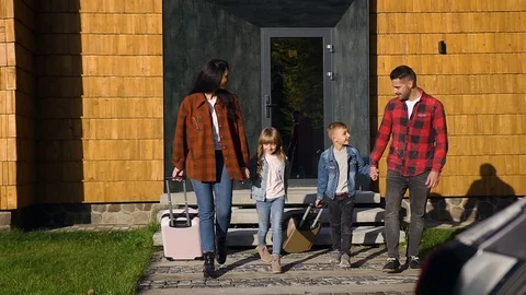 Front view of good-looking smiling family which loading their suitcases into Stock Footage 121659887