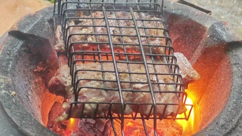 Front view of grilling pork on traditional clay stove. Stock Footage 341872534
