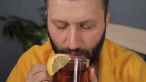 Front view guy is drinking black tea. Attractive young man is ill and drinks tea Vidéo 125296945