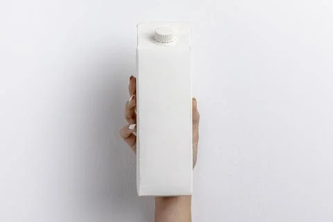 Front view hand holding simple milk carton Stock Photos