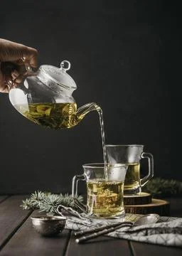 Front view hand pouring tea glass with teapot Beautiful photo Stock Photos