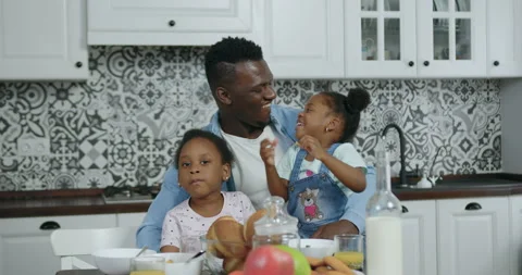 Front view of handsome happy loving african american which sitting near kitchen Stock Footage 144258135