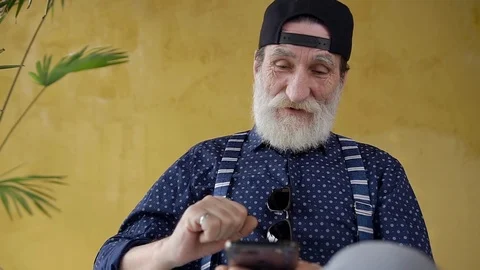 Front view of handsome high-spirited 70-aged bearded man in stylish cap which Stock Footage 125309162