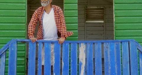 Front view of happy active senior African American man standing at beach hut on Stock Footage 106927429